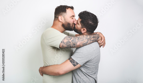 Young homosexuals gay couple love each other on a white background.