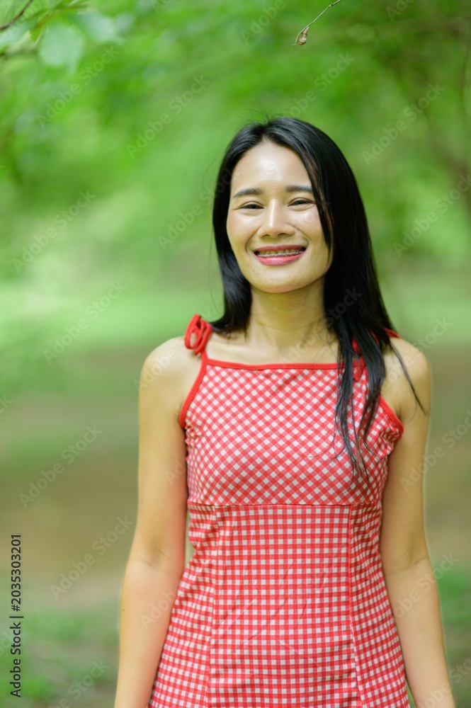 Fototapeta premium Woman in Red Dress Enjoying Nature in Beautiful Flower Garden