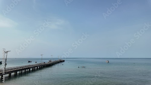 Long Pier Stretching into Calm Turquoise Sea Under Clear Sky