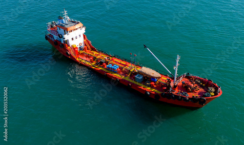 Drone shot of a red chemical tanker ship navigating beautifully across the ocean