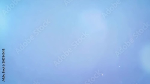 Soft clean blue sky with very light white gradient and subtle sun flare effect. Concept of peaceful clear weather and space for text templates
