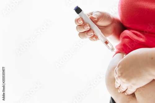 Woman with obesity making insulin pump into a belly