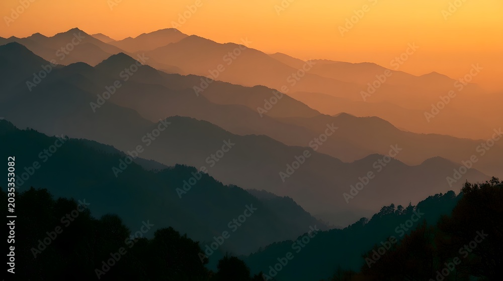 Obraz premium Serene misty mountains are bathed in a warm sunset glow creating a dramatic and exploratory landscape view