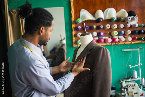 Cuadro en lienzo Photo showing african american tailor fitting suit on mannequin -stock photo