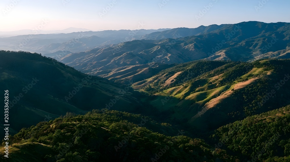 Obraz premium An aerial view of rolling mountains bathed in warm evening light creating a serene and majestic landscape