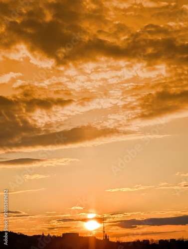 Summer sunny over the town. Yellow orange colorful tones. Vertical composition of magic scenery brown clouds. Warm summer mood.