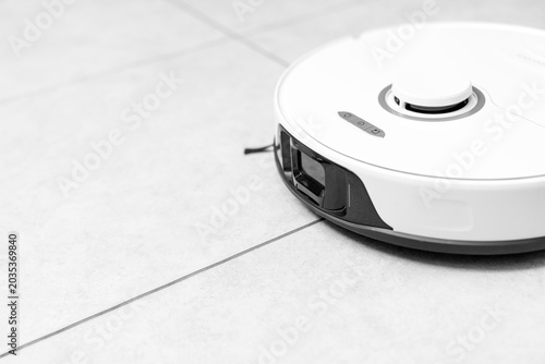 Schilderij op canvas robot vacuum cleaner in modern smart home, robotic vacuum cleaner on tiles floor, Robot vacuum cleaner cleaning dust on tile floors