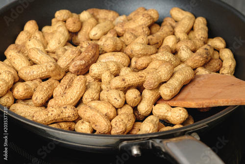 Roasting fresh peanuts in a skillet for a delicious snack experience