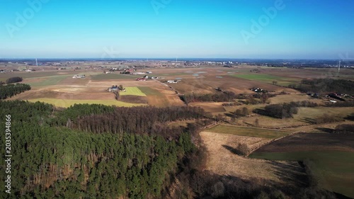 Forward drone flight above forest and agricultural countryside
