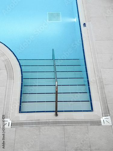 Φωτογραφία Modern indoor swimming pool entrance with stainless steel handrail, clear blue w