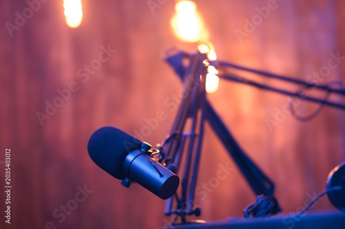 Inside a lively podcast studio, a sleek microphone awaits its next conversation, illuminated by warm lights that set the tone for exciting discussions