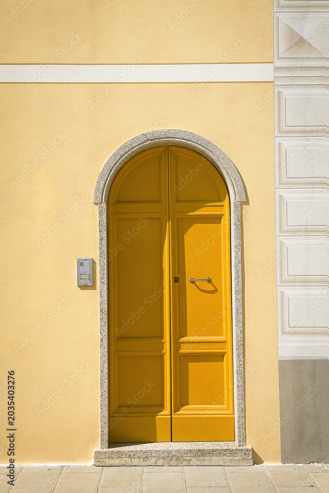 Fototapeta premium Minimal yellow mediterranean door on pastel facade