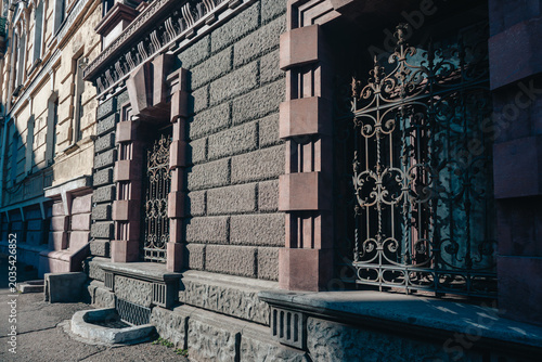 Classic stone facade with decorative iron gate and detailed architectural elements. Urban street scene with historic charm