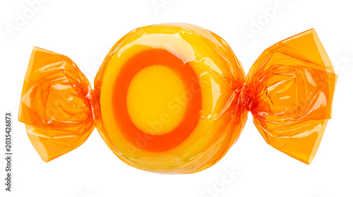 A round orange candy with yellow and orange rings inside, wrapped in crinkled orange cellophane