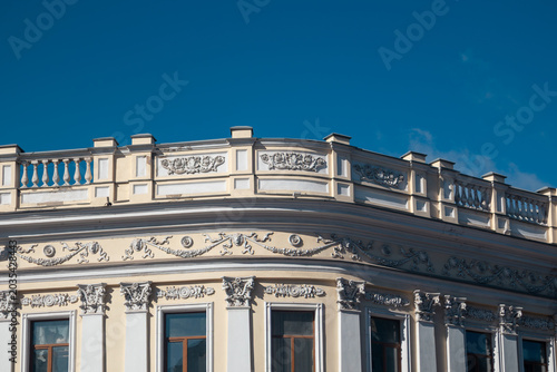Detailed ornate european architecture with balustrade and columns with blue sky