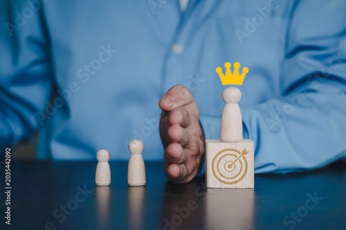 Foto Hand protecting a crowned leader on target block from others