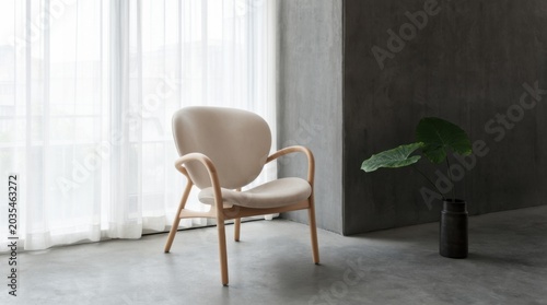 Modern chair in minimalistic interior with natural lighting and decorative plant in vase. Interior features sleek design and soft cushioning with elegant simplicity.
