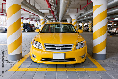 Bright yellow car parked in a parking garage space