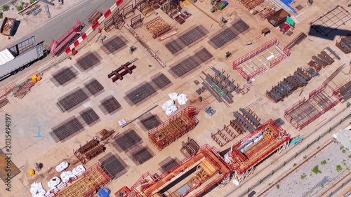 Aerial view of heavy steel rebar mesh and industrial reinforcing bars stacked at a massive civil engineering infrastructure construction site.