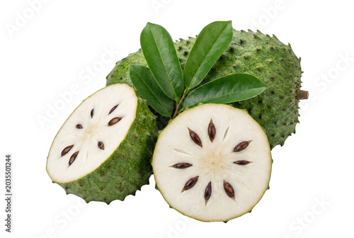 Fresh soursop fruit whole and sliced showing white pulp and seeds with leaves