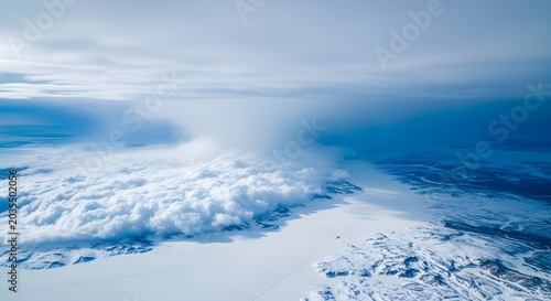 Aerial view of a vast arctic landscape with clouds and snowcovered terrain