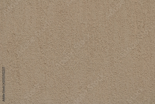 Textured Beige–Grey Plaster Wall Background. Warm beige and earthy grey scratched‑plaster wall texture with subtle brownish tones, ideal as a natural background.