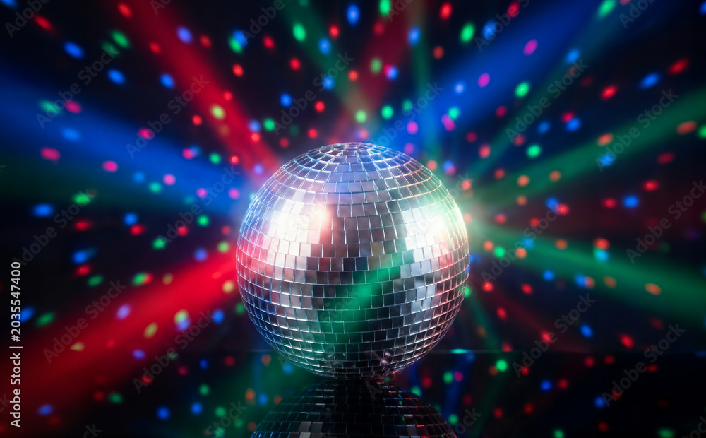 Obraz premium Disco ball spinning and reflecting colorful lights in dark setting creating vibrant atmosphere for celebration and party event with energetic mood and festive ambiance for dance music a