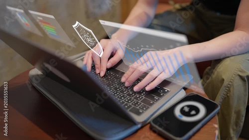 A person works on a laptop with holographic AI security shield and data charts, representing cybersecurity protection and business intelligence for corporate or tech presentations.