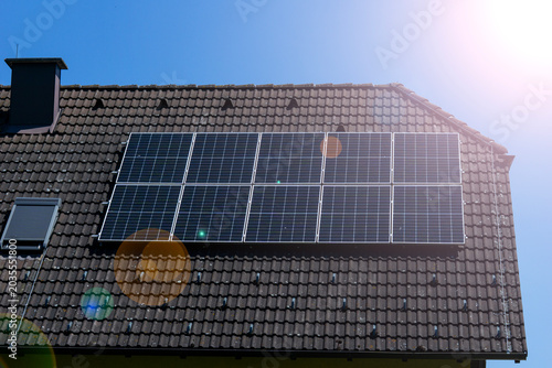 Bild auf Leinwand solar panels roof house sun lens flare photovoltaic cells installation on tiled
