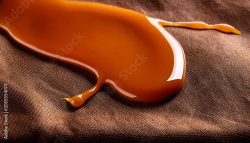 Sticky Caramel Sauce Dripping Onto Brown Fabric Close Up