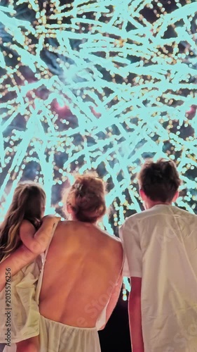 Mother with kids watch the beautiful fireworks on the ocean coast