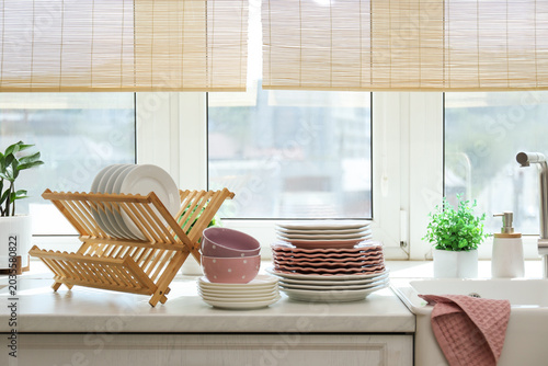 Canvas Print Set of clean plates and bowls on white countertop in kitchen