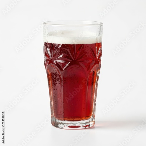 Tall glass of dark red beer with white foam head isolated on white background.