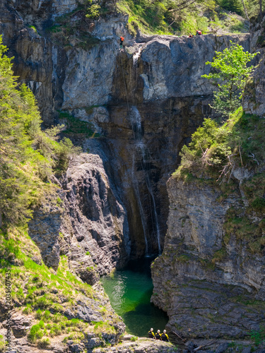 Photography Canyoning Adventure Rappelling Down a Rocky Waterfall Gorge With Team in Green P