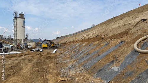 Construction of railway line LK104 with advanced ground stabilization and engineering structures. Geotechnical works including pile walls, soil reinforcement, ground nails, and slope protection system