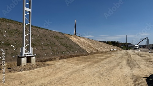 Construction of railway line LK104 with advanced ground stabilization and engineering structures. Geotechnical works including pile walls, soil reinforcement, ground nails, and slope protection system