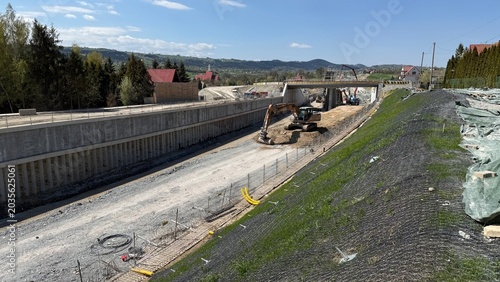 Construction of railway line LK104 with advanced ground stabilization and engineering structures. Geotechnical works including pile walls, soil reinforcement, ground nails, and slope protection system