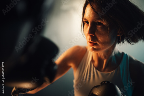Obraz na płótnie Female boxer training with determination, sweating during a vigorous workout, sh