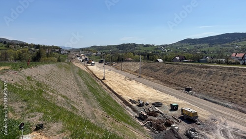 Construction of railway line LK104 with advanced ground stabilization and engineering structures. Geotechnical works including pile walls, soil reinforcement, ground nails, and slope protection system