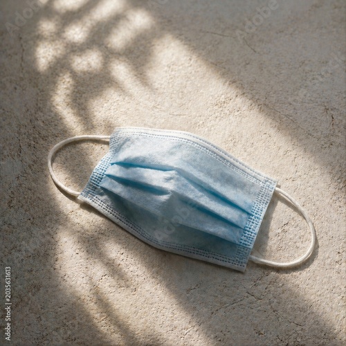  Blue Surgical Face Mask on Sand with Natural Sunlight Shadow