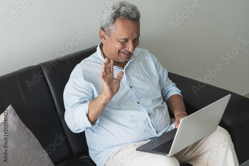 Senior man connecting with family during video call