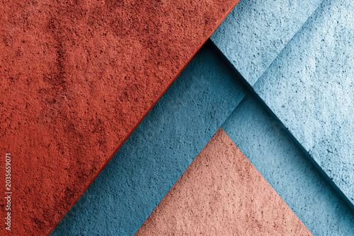 Textured abstract background featuring overlapping layers of red, blue, and beige paper with a rough surface, creating a visually striking geometric composition