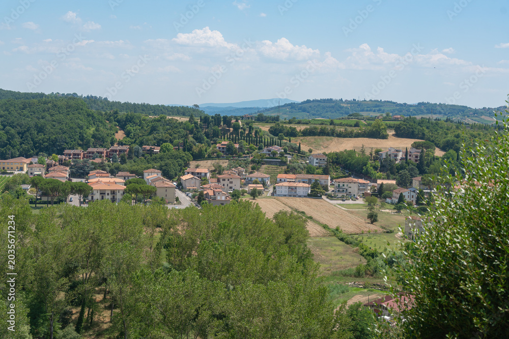 Fototapeta premium Tuscan rural landscape featuring traditional houses among wooded hills. Authentic regional scenery of Certaldo, Italy