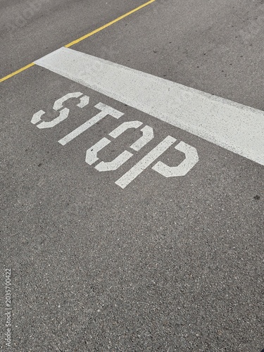 Stop Sign Painted on Asphalt Road with Urban Street Markings and Traffic Safety Perspective