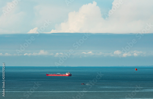 Ship in the sea under blue sky and clouds