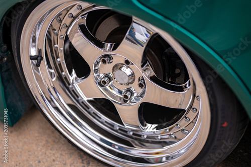 Close up view of a shiny chrome deep dish aftermarket alloy wheel fitted on a modified car.