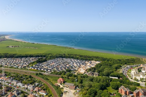 Aerial drone view of the Saltburn by the Sea coastline in North Yorkshire showing caravan parks countryside railway tracks and the North Sea on a hot sunny summers day