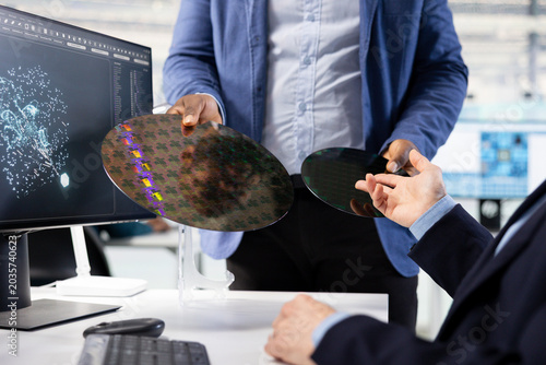 Bild auf Leinwand Close up of microchip designer inspecting silicon wafer substrates with AI deep learning, Experts using neural network tech to analyze semiconductor slice in manufacturing plant research facility
