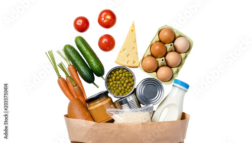 Принти на полотні Isolated diverse fresh groceries and essential pantry items spilling from a brow