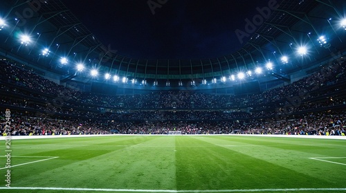 Football stadium field at night with a full crowd under floodlights
